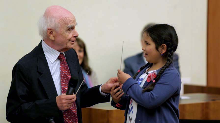 Ervin Laszlo, symbolically handing a 'Conductor's baton' to the younger generations